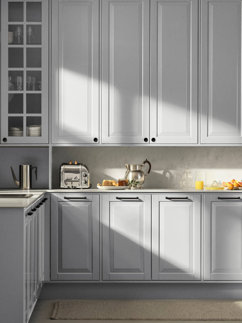 Lys grå landkøkken Nordic Sky fra INVITA med fyldningslåger, sort håndtag, vitrineskab med sprosselåger og hvid marmor laminatbordplade