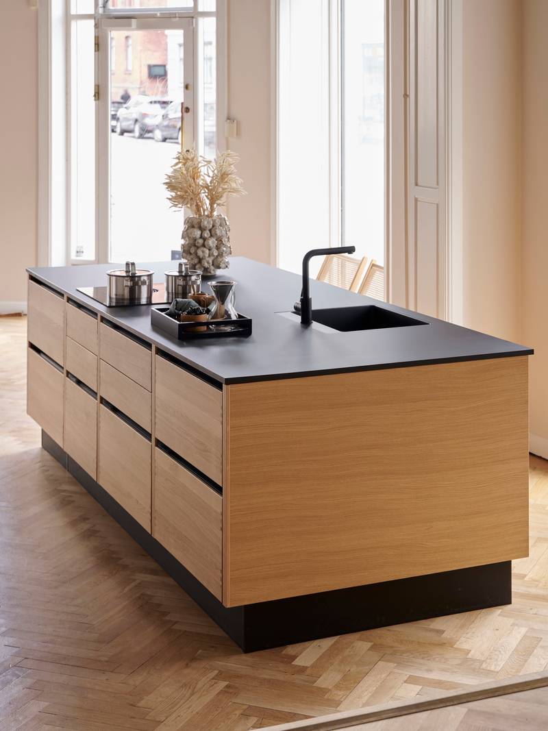 Køkkenøya Glød fra INVITA , skuffer i massivt egetræ med fingertappede samlinger og sort granit bordplade