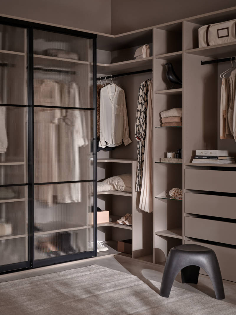 Walk-in garderobe med glasskydedøre med sort metalramme