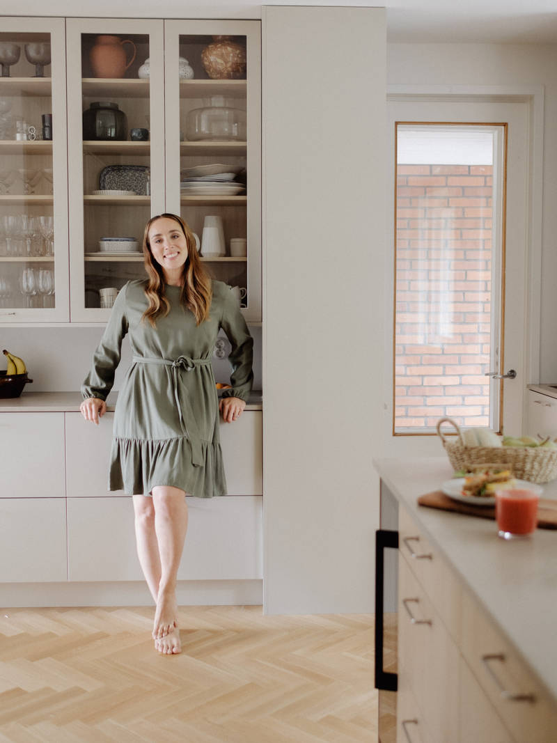 Anni Ihamäki toimivassa melamiini- ja laminaattikeittiössä Hiekassa ja lämminsävyinen vaalea tammimelamiini Novartilta, vitriinikaapeilla ja Quartz-tasolla