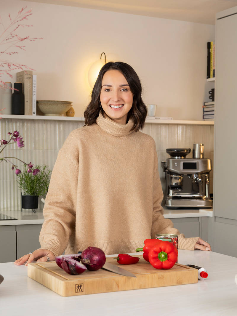 Yasmin Wyatt standing by the kitchen island, smiling to the camera.