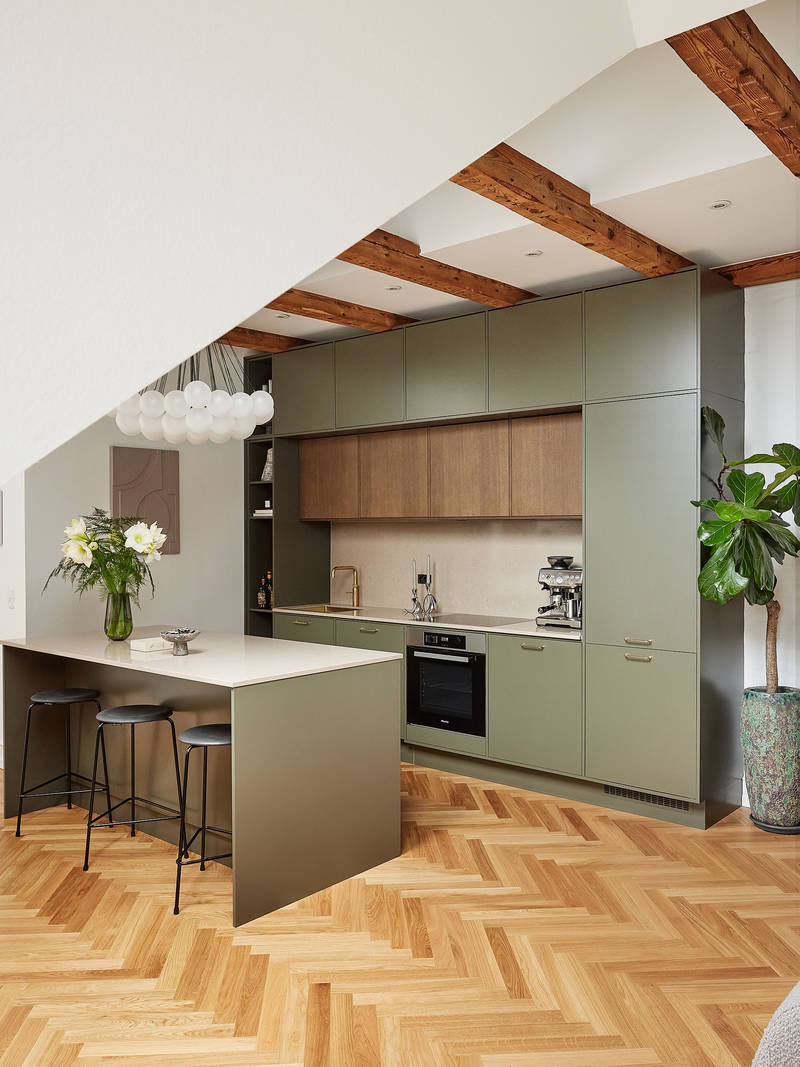 Grønt køkken med træskabe og køkkenø