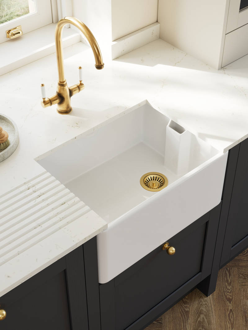 Overhead view of veramic belfast sink and brass tap in Contemporary Shaker kitchen Ambleside from Magnet in deep blue shade Lake with beige tall cabinets