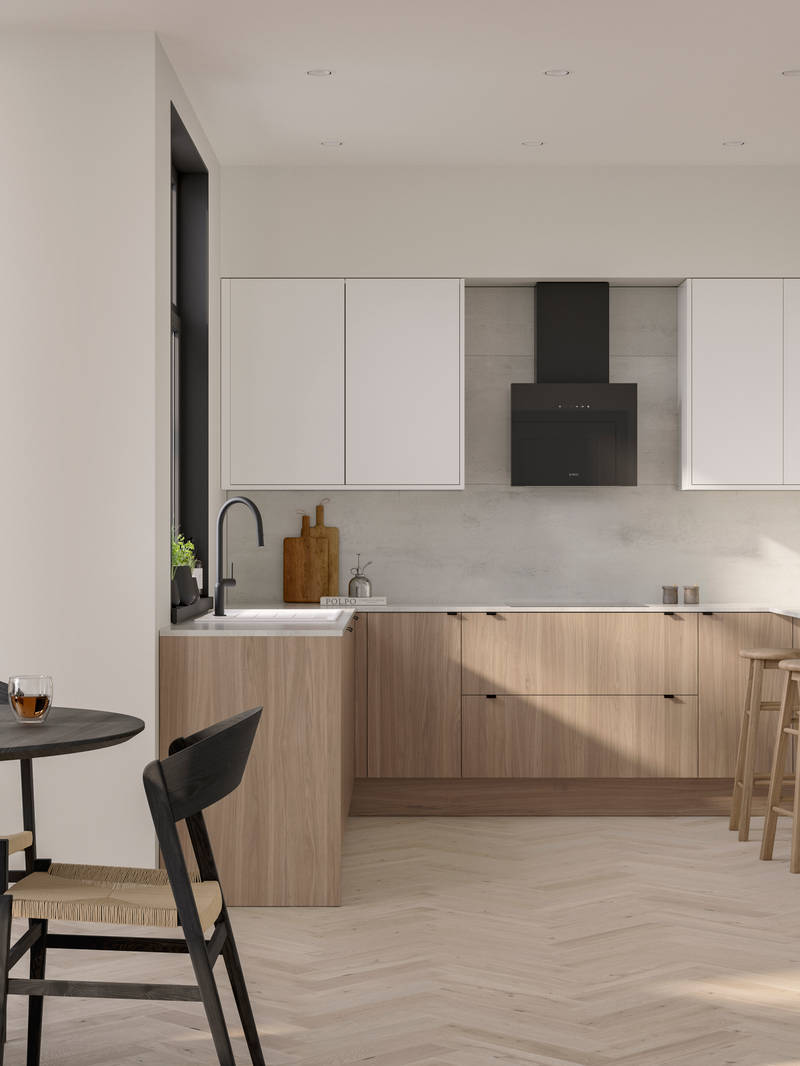 Open floorplan Ascoli kitchen from Magnet with Natural Oak cabinetry, a white worktop, Ascoli Gloss white wall cabinets over countertop and matching tall cabinets with a built-in oven all paired with small black handles, a black tap and black hood.