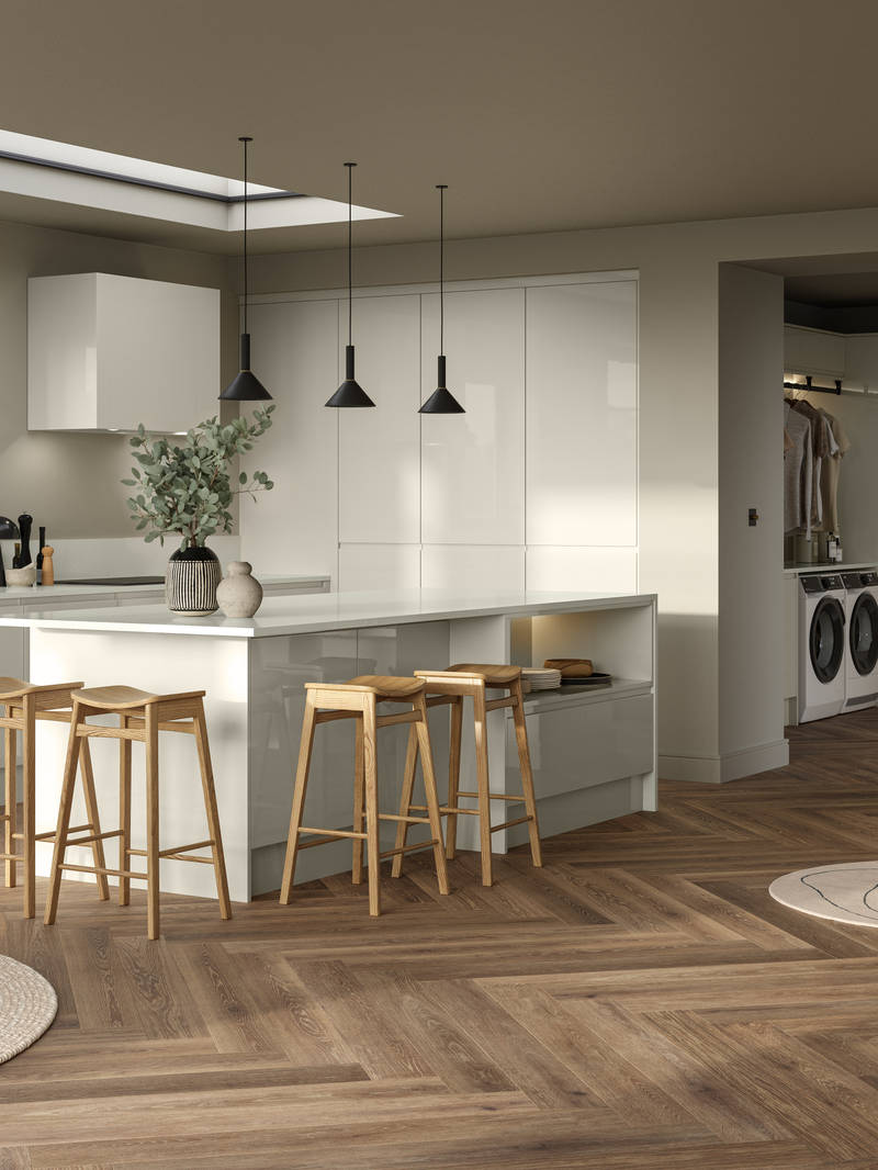 Full room view of open plan contemporary Luna Gloss kitchen with a kitchen island, breakfast bar with wood stools, tall cabinetry, matching open shelves in living room with natural material decorations and Amtico smouldering oak parquet flooring.