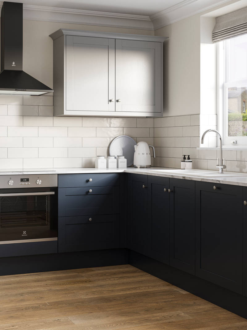 Tatton kitchen from Magnet with cabinetry in dark blue shade Midnight paired with light grey wall cabinets over countertops, white worktop. and white sink by a window.