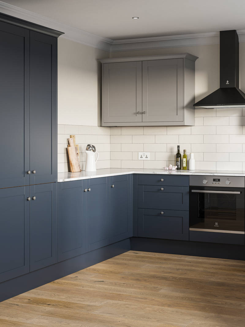 Tatton kitchen from Magnet with tall cabinets and matching kitchen counter cabinetry in dark blue shade Midnight paired with light grey wall cabinets over countertops, white worktop.