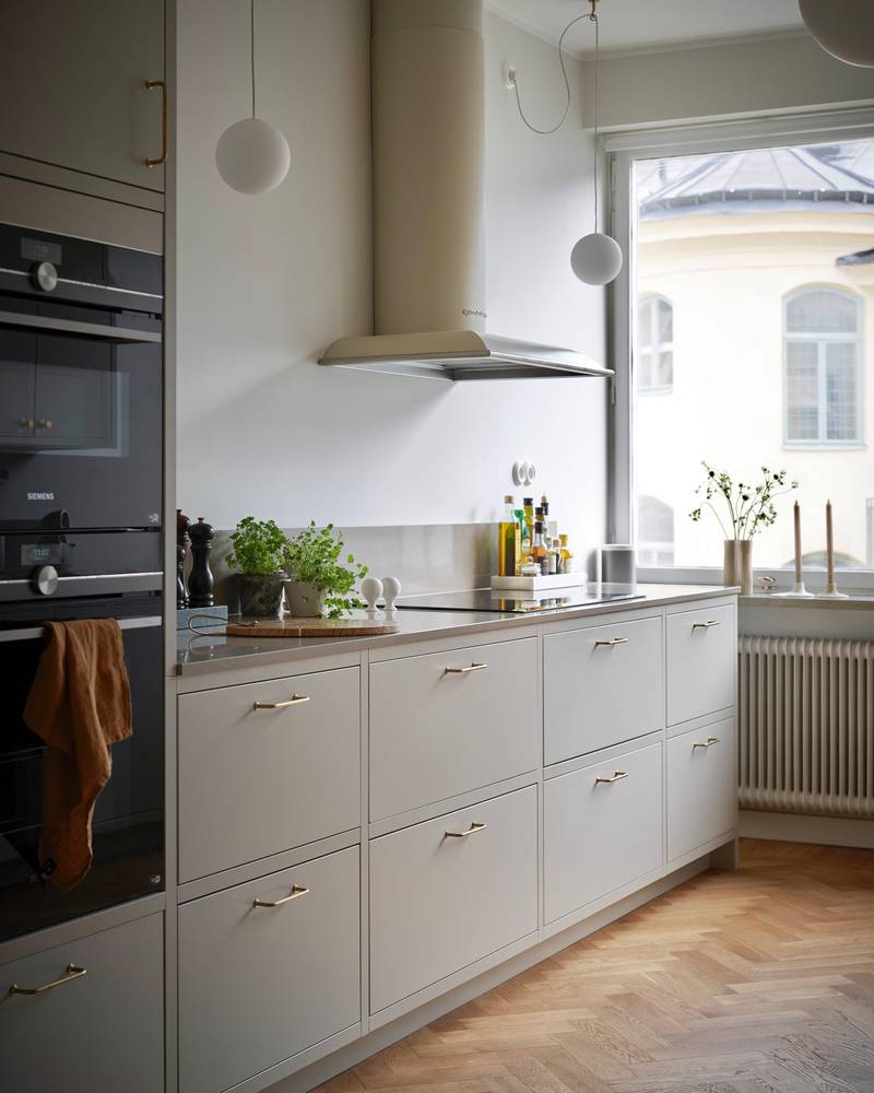 Forrammekøkken Athena Fusion i lys grå farve Sky fra INVITA med grå stein bordplade, rustfrit stål håndtag