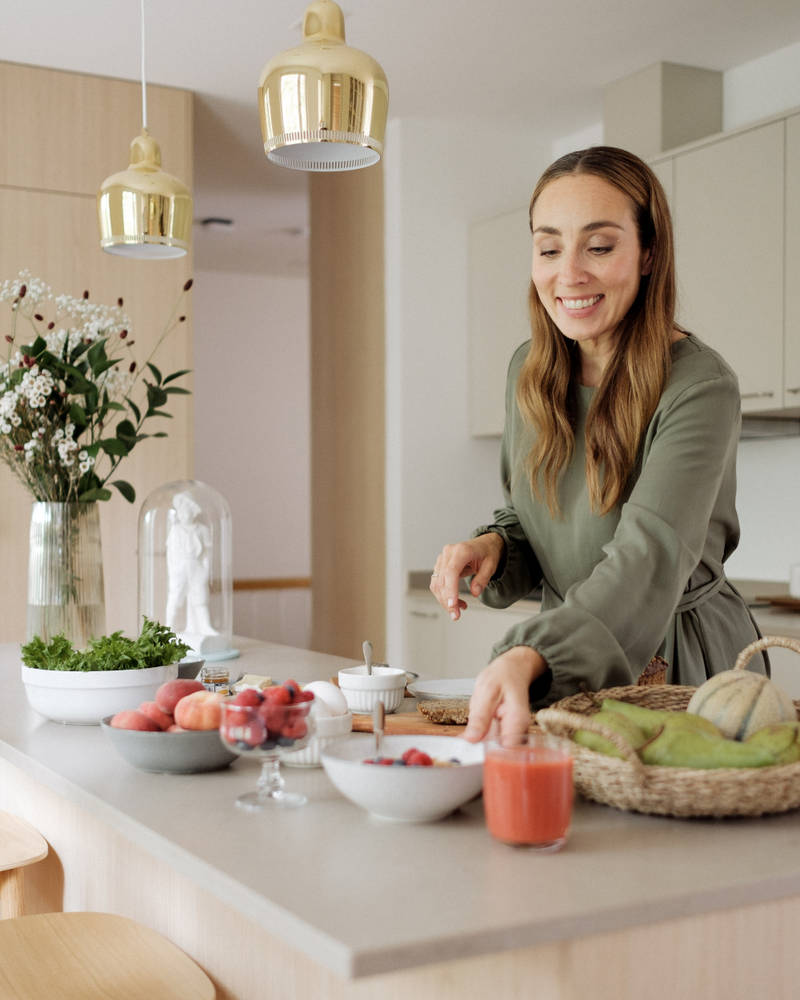 Anni Ihamäki toiminnallisessa melamiini- ja laminaattikeittiössä Hiekassa sekä lämminsävyinen vaalea tammimelamiini Novartilta, yhdistettynä kromilankakahvat ja helppohoitoinen Coral Clay mokkanahkakvartsitaso.