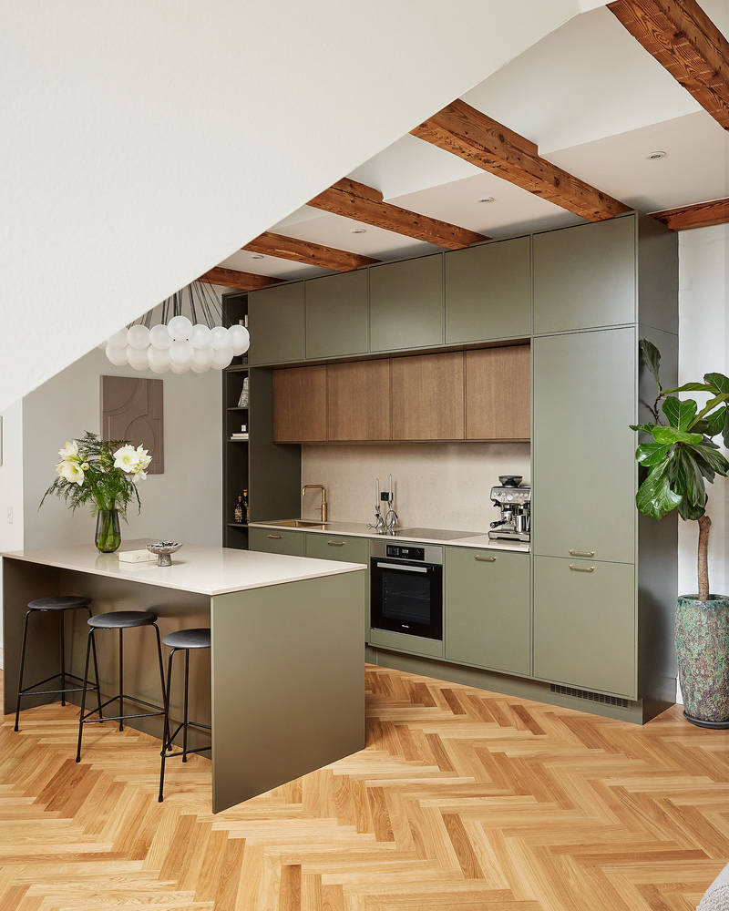 Grønt køkken med træskabe og køkkenø