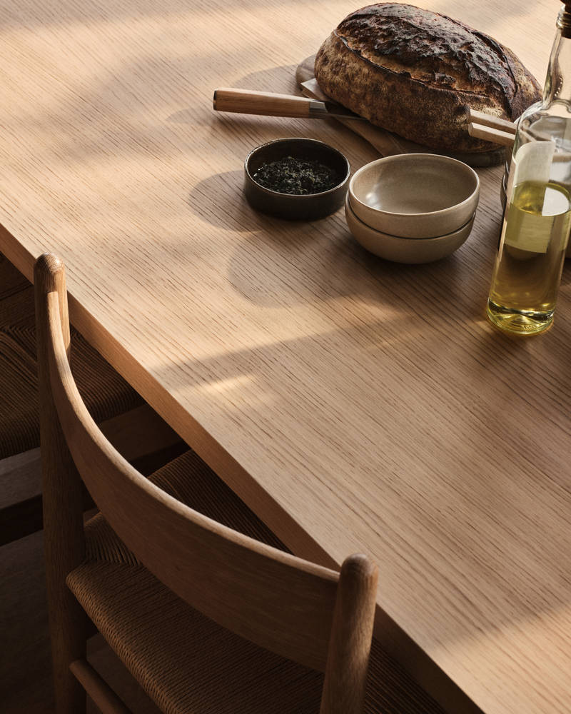 Bord och stol i trä med keramik och en flaska olivolja