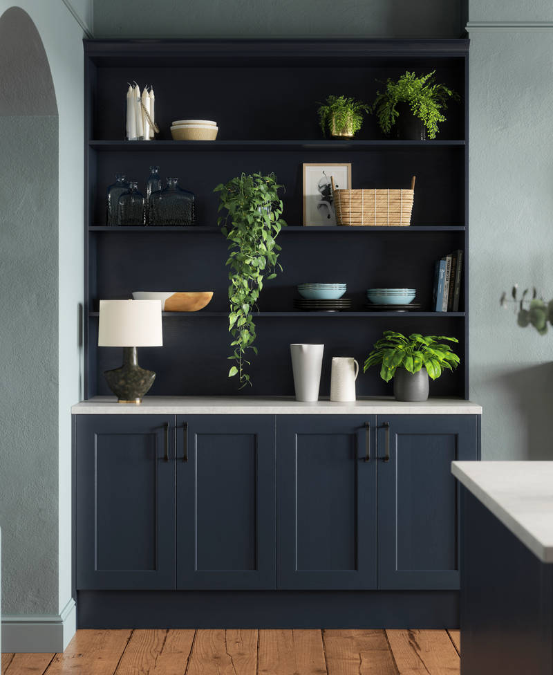 Modern country-style Ludlow Shaker kitchen in dark blue shade Midnight with matching blue open shelves and wall in open floorplan kitchen.