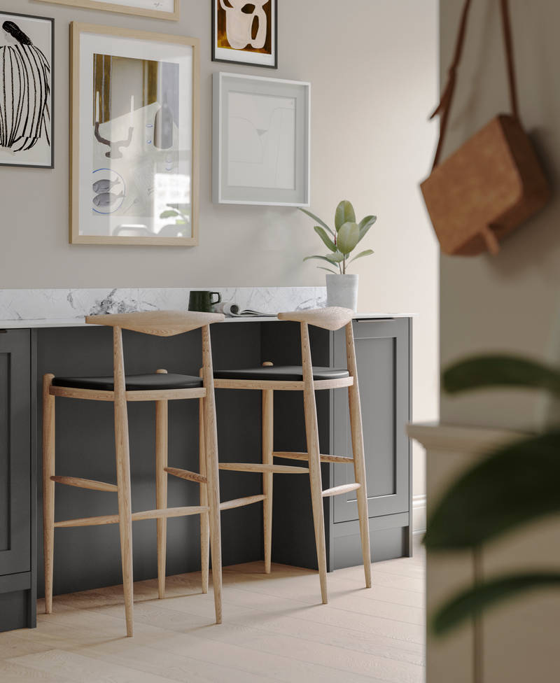 A dark grey Shaker bar sideboard with Charcoals cabinetry, paired with marble splashback and wooden high chairs.
