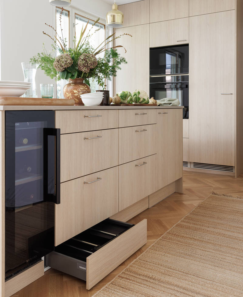 Aitoa luonnontammea Novartilta, yhdistelmä yhteensopivia puisia ja painonappikahvoja, keittiösaareke hanalla, tiskiallas ja ruostumattomasta teräksestä valmistettu työtaso.