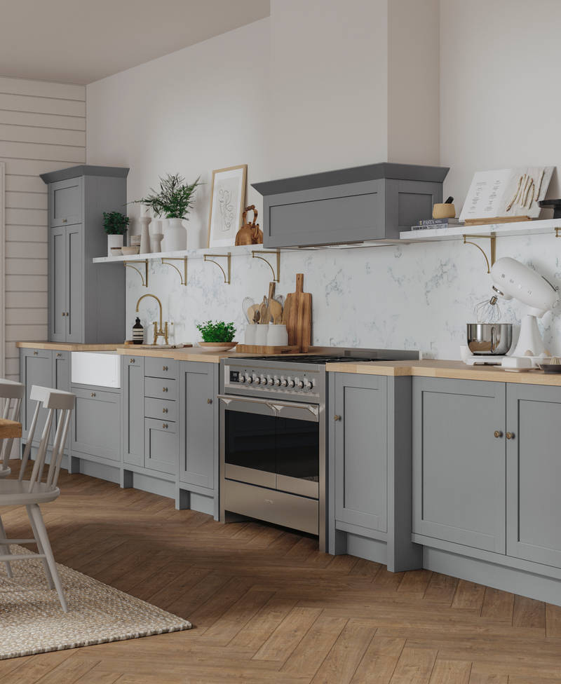 A grey Shaker kitchen seen with a wooden dining table and accessorised with plants.