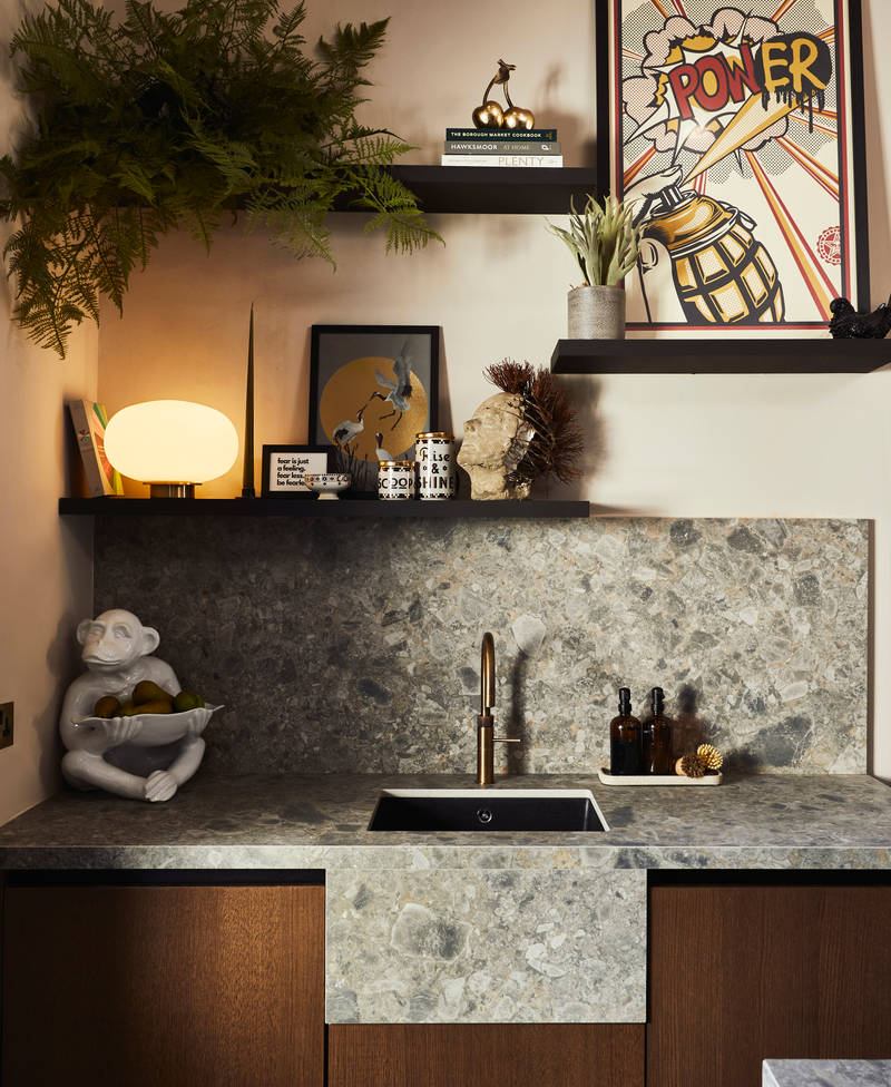 Sink area with Dekton in Ceppo backsplash and worktop, Nordic Nature cabinetry and a brass Quooker tap, combined with plants on open shelves on wall