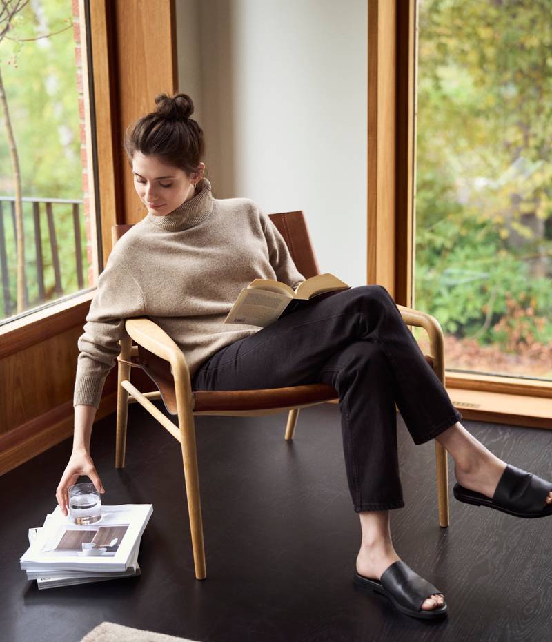 Kvinde leser katalog i fåtølj