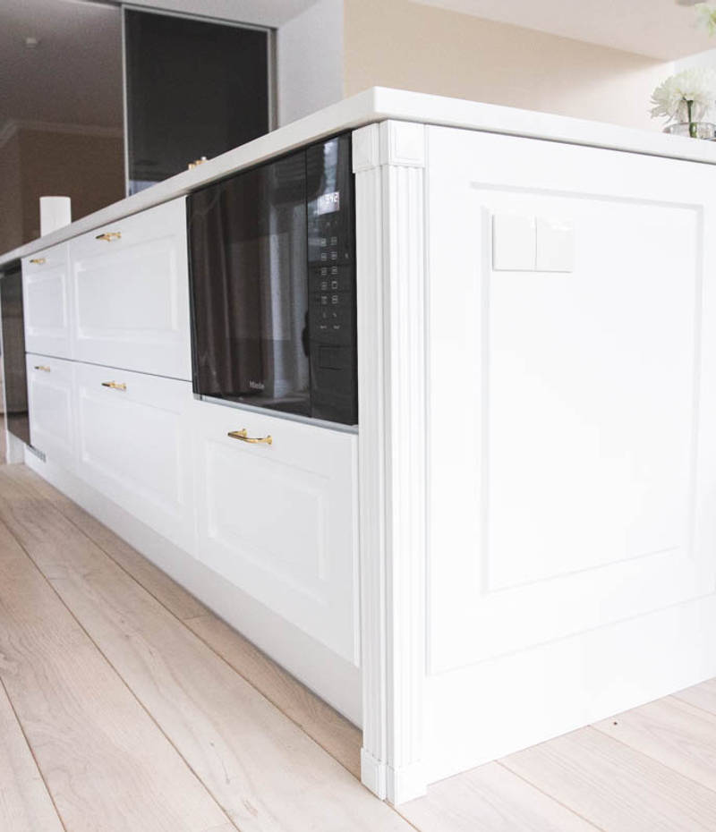 Keittiösaareke, jossa sisäänrakennettu mikroaaltouuni, viininjäähdytin ja koristeelliset sivut, jotka sopivat tyylikkäiden maalattujen karmiovien kanssa.