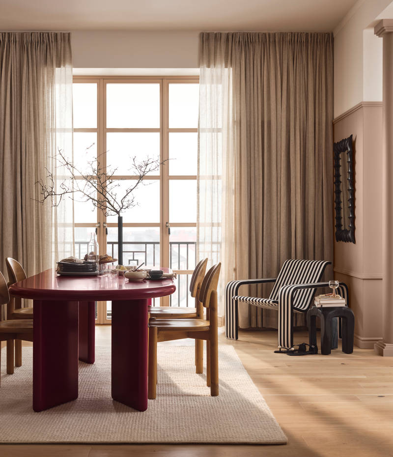 Öppet ochljust rum med naturfärger, designmöbler, trägolv och beige väggfärg