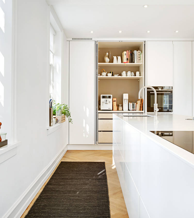 Det vita köket har ett högskåp med fickluckor