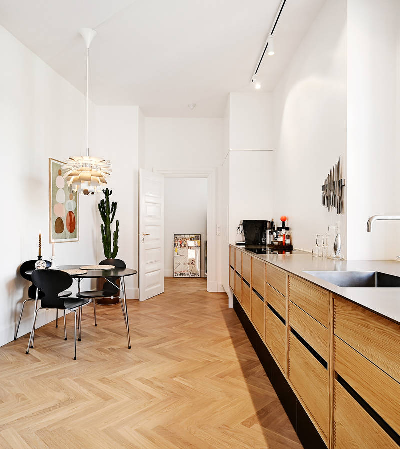 Kitchen in oak with black plinth and table top in curled steel