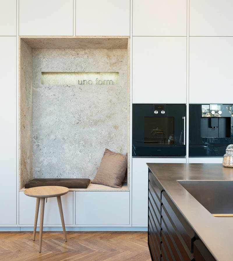 Köksö i rökt ek med stålbänkskiva och vit högskåpsvägg med alkov