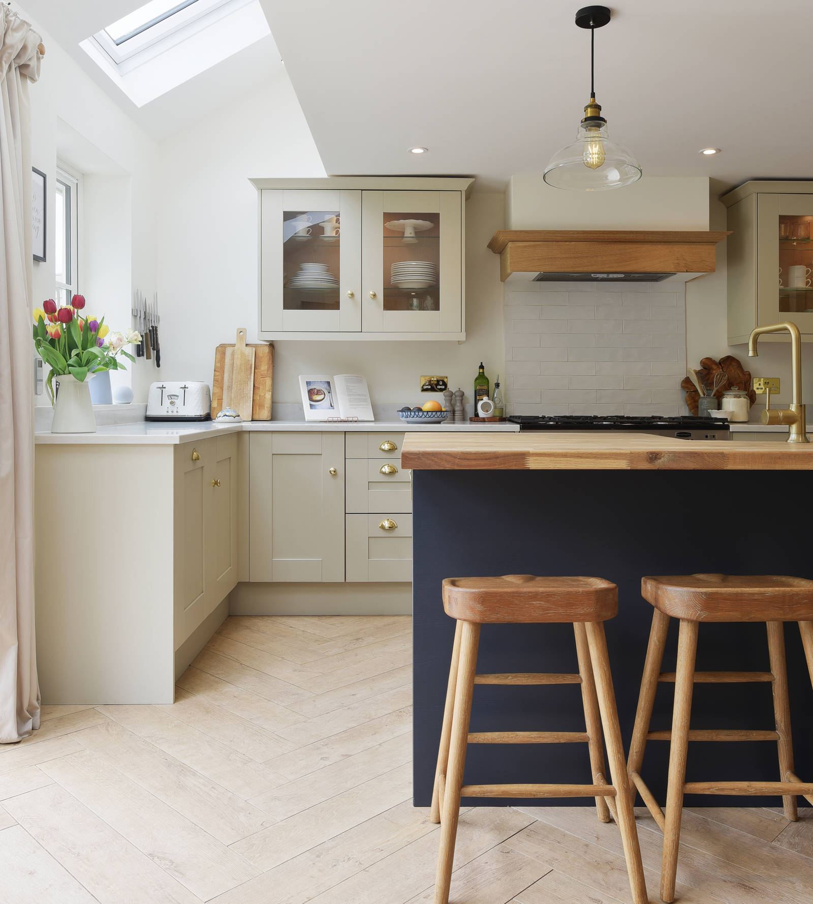 View of bar stools by the kitchen island in the Shaker-style country cottage kitchen from Magnet