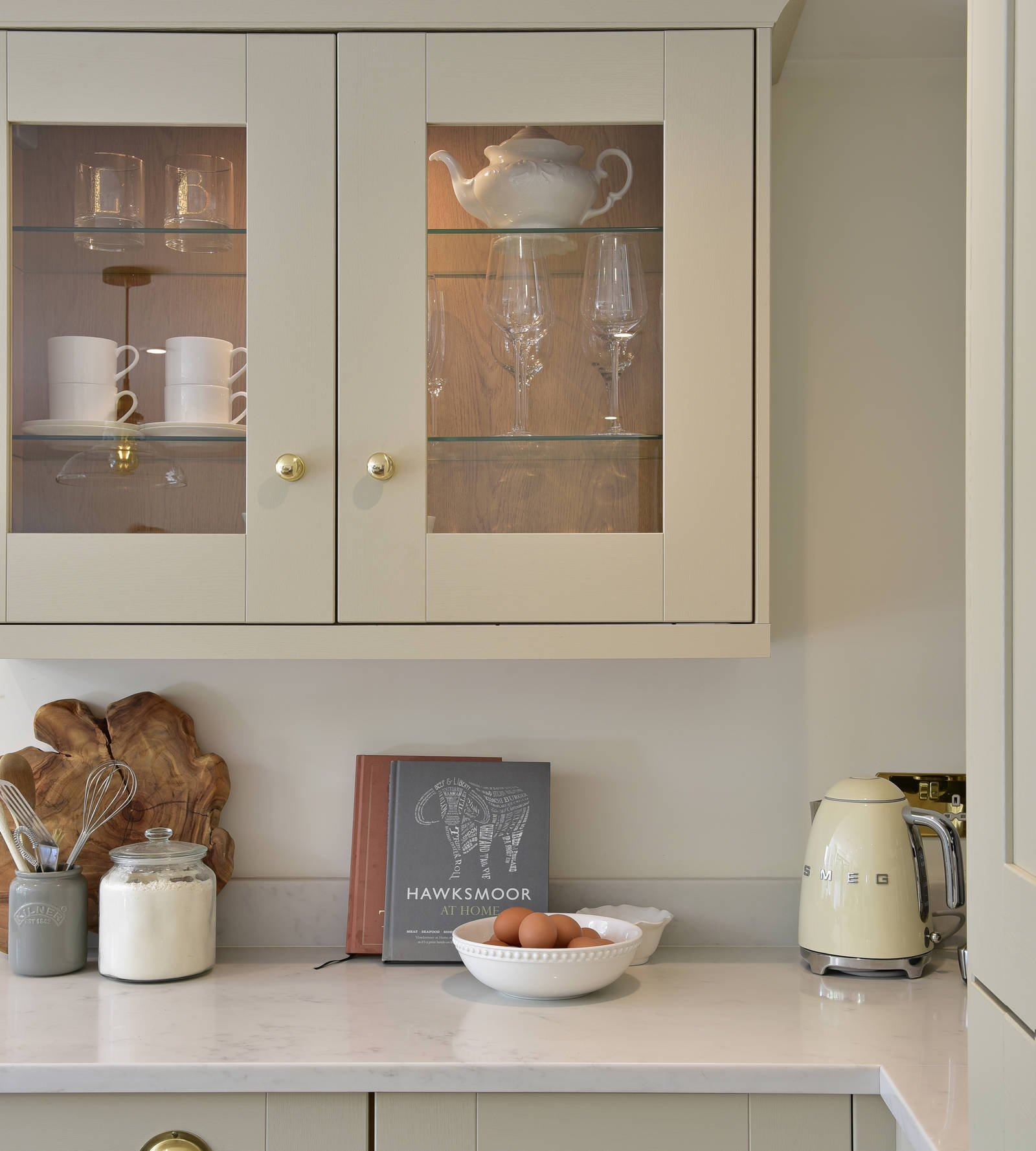 Wall cabinets in the shaker-style kitchen, with matching wooden frames and glass.