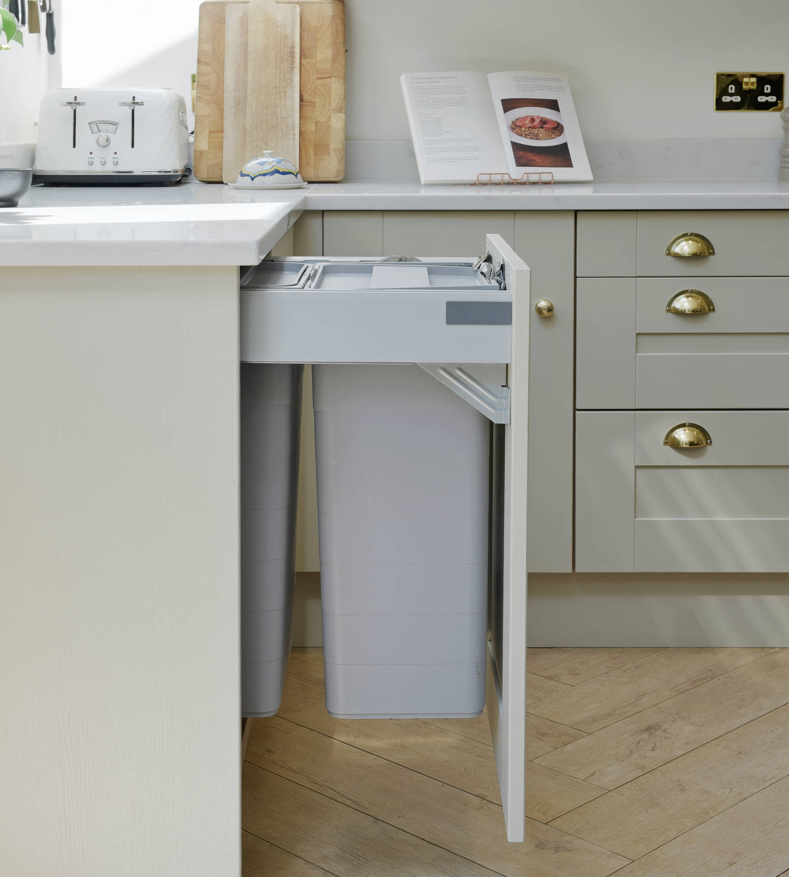 Pulled out waste bin in Shaker-style kitchen, integrated behind a frame foor front