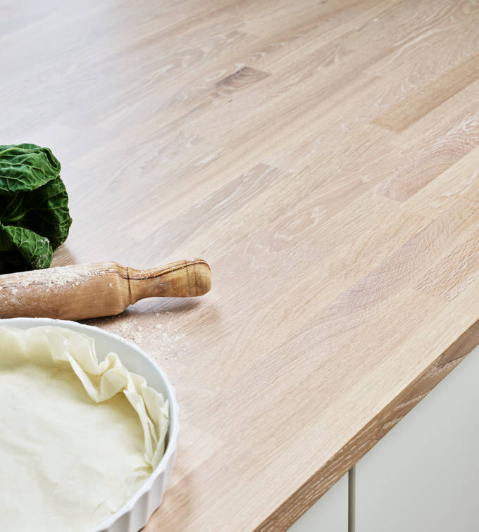 Mild og godlynt kjøkkenmodell i lys eik med liggende trestruktur og innfreste grep.