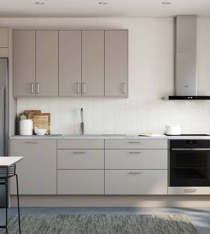 Tidlösa och stilrena Arkitekt Plus från Marbodal i greige kulör Frö, integrerade ugn och kyl/frys i rostfritt stål.