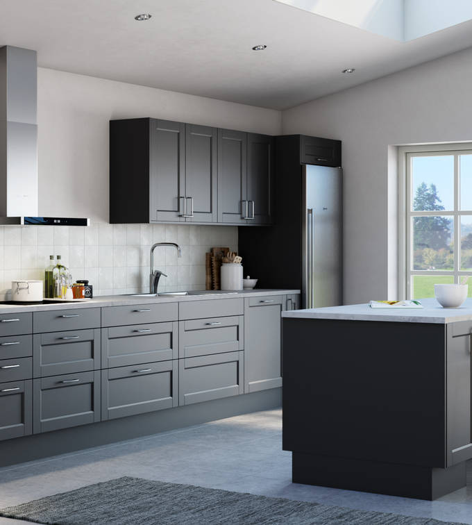 Det både klassiska och lantliga köket Fagerö med ramlucka i den mörkgrå kulören Granit, med integrerade ugnar och kyl/frys i rostfritt stål, och köksö.