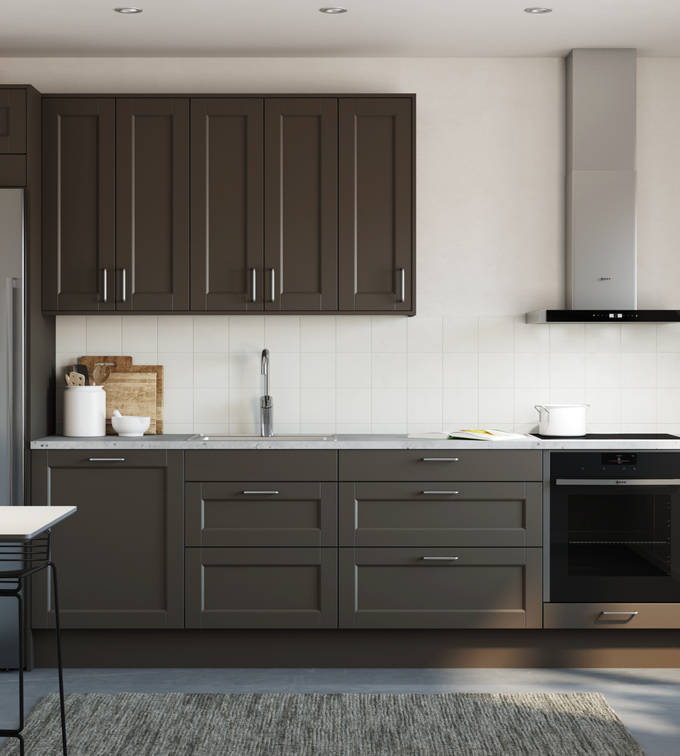 Det både klassiska och lantliga köket Fagerö med ramlucka i den bruna kulören Bark, med integrerad ugn och kyl/frys i rostfritt stål, i ett litet kök.