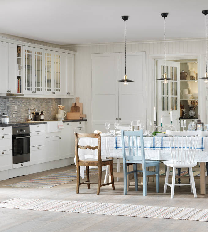 Köket Fagerö Frost. Tillsammans med vackra vitriner, matchande kakel och lugna färger ger detta kök en känsla av skärgård och med en flirt åt tidigt 1900-tal. Bänkskivan med stenkaraktär och en tidstypisk blandare i nedfälld porslinsho förstärker intrycket ytterligare.