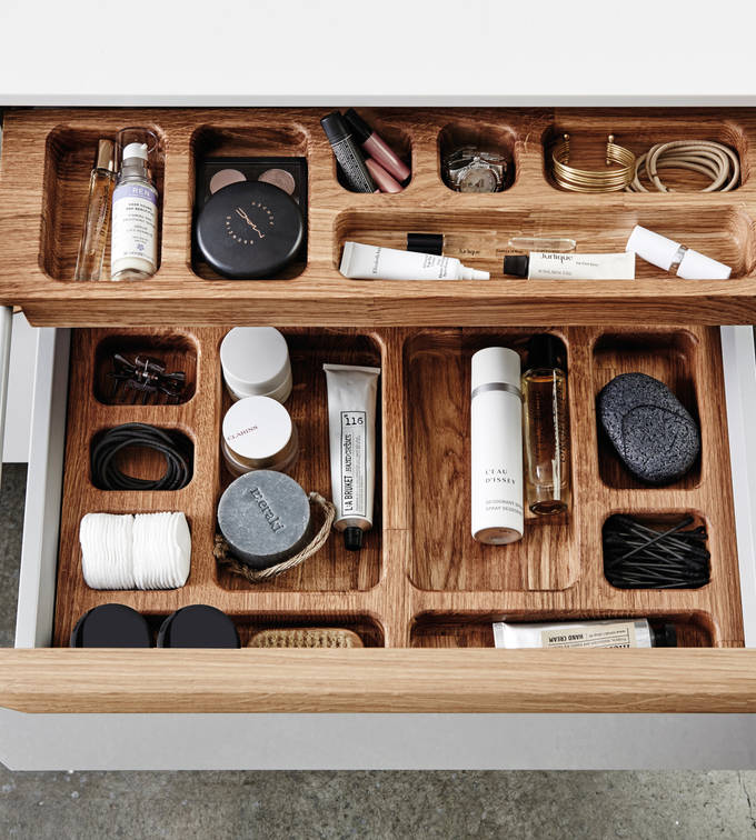 Nærbillede af åben badeværlsesskuffe med tre indsats i luksuriøs grå badeværelsesmøbel Everline fra INVITA med massive trægreb