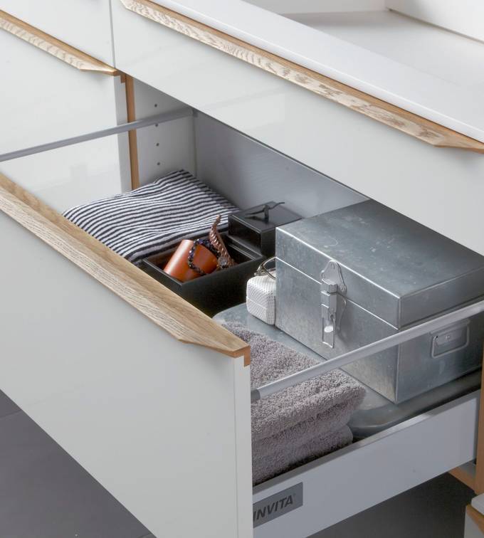 Nærbillede af åben badeværlsesskuffe i luksuriøs grå badeværelsesmøbel Everline fra INVITA med massive trægreb
