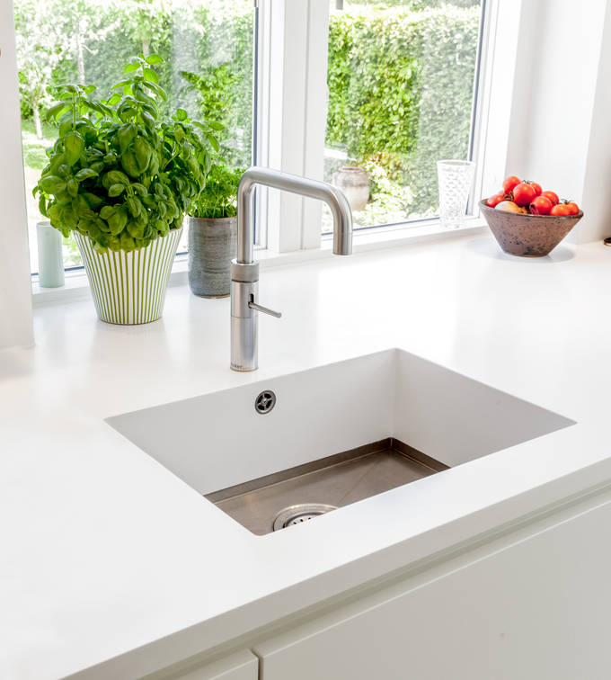 Grebsfrie hvide køkkenet Highline Frost med indfræsede greb i lågerne fra INVITA, hvid bordplade og armatur i rustfrit stål