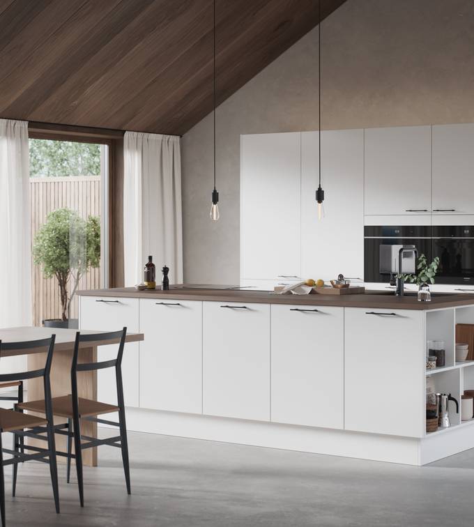 Hvit kjøkken og kjøkkenøy med slank og elegant front med svakt avrundede kanter, Corestoen varm sement benkeplate, sort vask og sort kran, håndtak i sort støpejern.