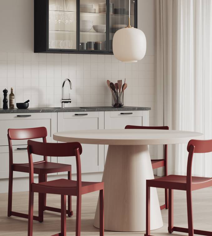 Hvit kjøkken med ramtrefronter, sort aluminiumvitrineskap och spisebord med rød stoler.