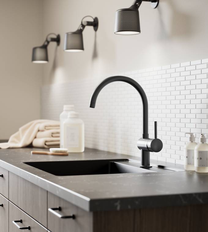 Nærbilde av baderomsskap i mørkt tre med sort vask og armatur.