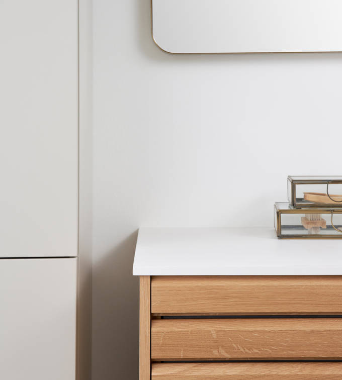 Nærbillede af hjørne i snedkerbadeværelse Ikon Finér eg natur fra INVITA med håndplukkede, massive egetræslameller med hvid vask