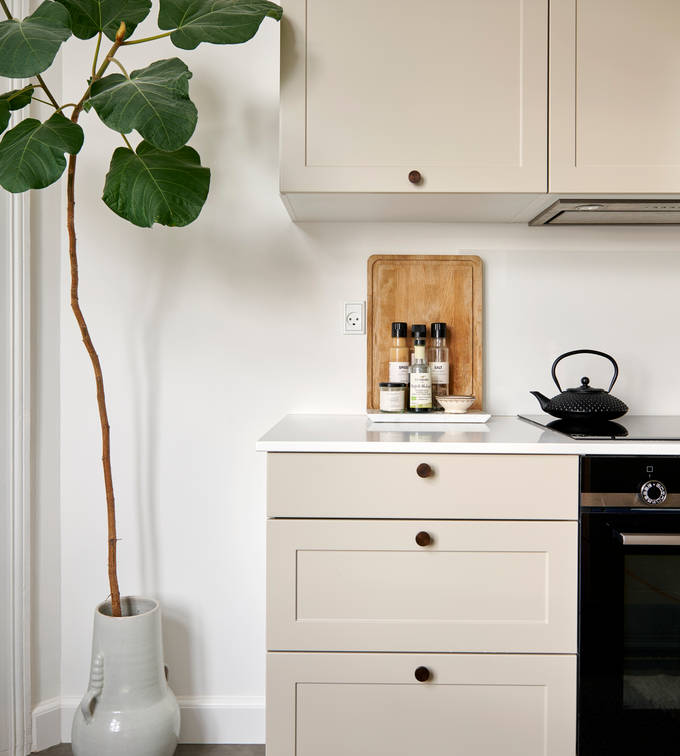 Beige retrokøkken Square Sand køkken fra INVITA med messing håndtag, hvid bordplade