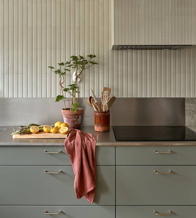 Lys grågrøn Athena Salvie køkken fra INVITA, håndtag och bordplade med splashback i rustfritt stål