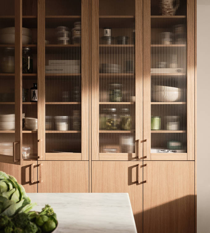 Siri Barjes kök Ekbacken från Marbodal, högskåp med ekluckor och vitrinluckor med ram i ek, matchande handtag i trä, köksö.