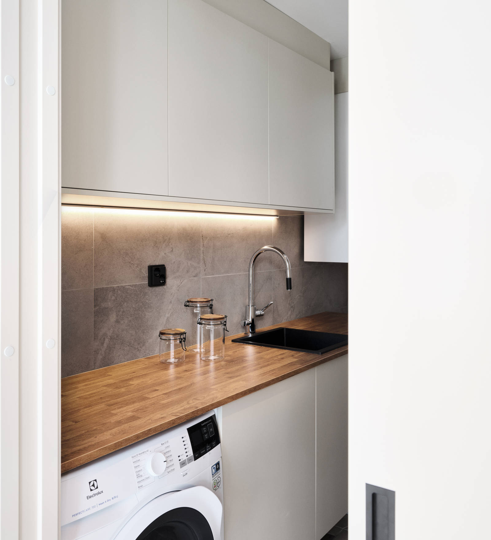 kodinhoitohuoneen ovimalleina toimii melamiini värissä Hiekka ja tasoksi valikoitui helppohoitoinen ja kestävä laminaatti sävyssä antiikkitammi.