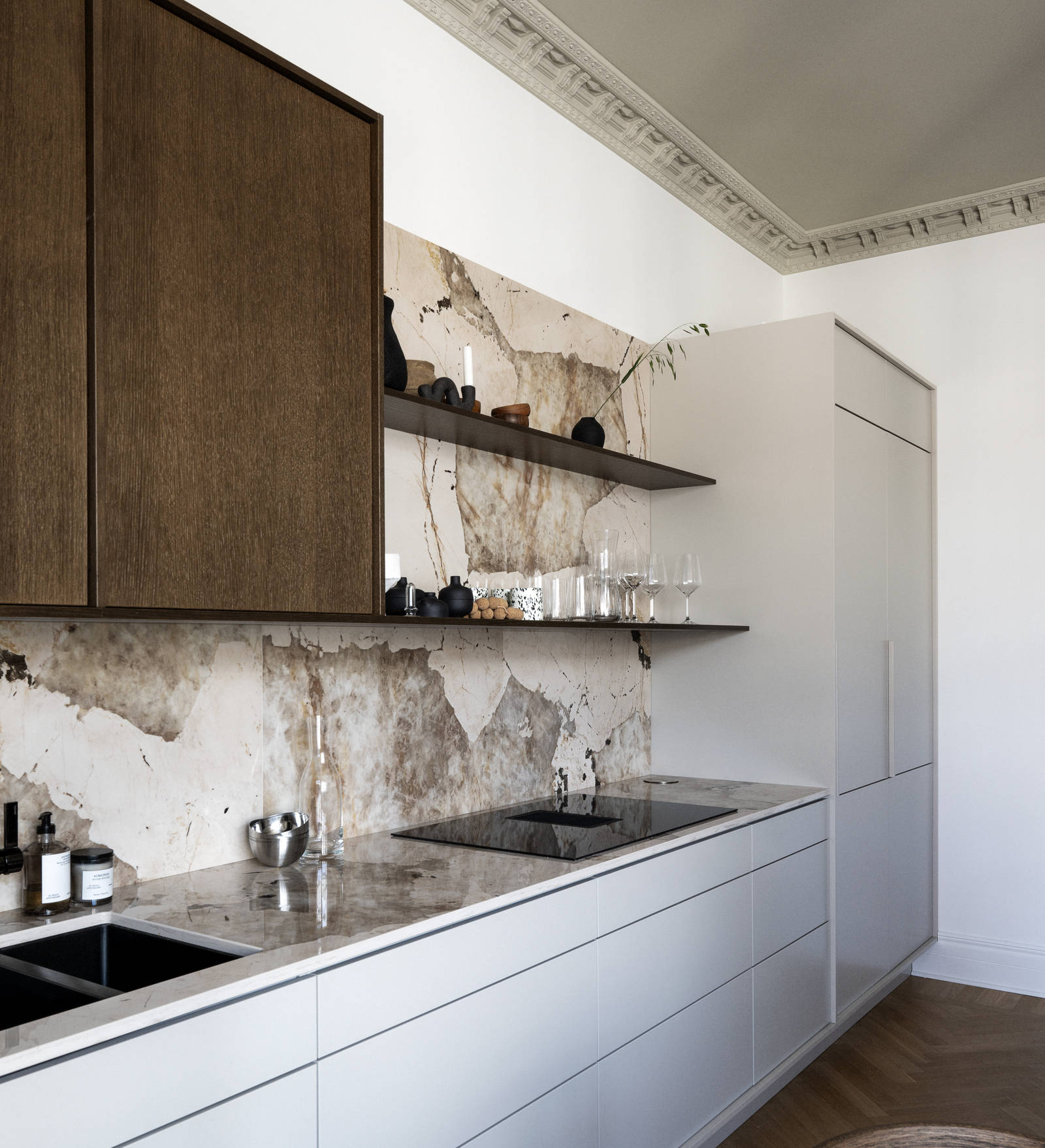 Kjøkken med kombinasjon av kjøkkenbenk og høyskap i beige Line Korn med overskap i Favn finert eikedør i brunbeis fra Sigdal, benkeplate og sprutbak som matcher og åpne vegghyller i brunbeiset eikefiner.