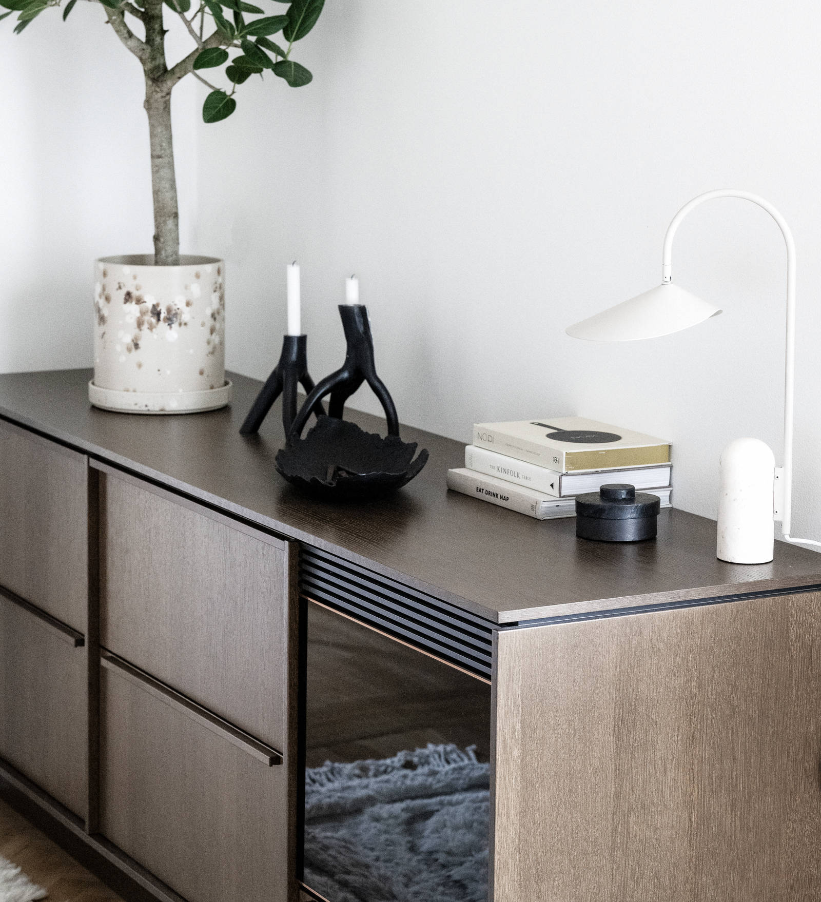 Nærbilde av et benkskap med møbelaktig preg som en skjenk med innebygget vinkjøler, i Favn brunbeiset eikefiner med matchende håndtak.