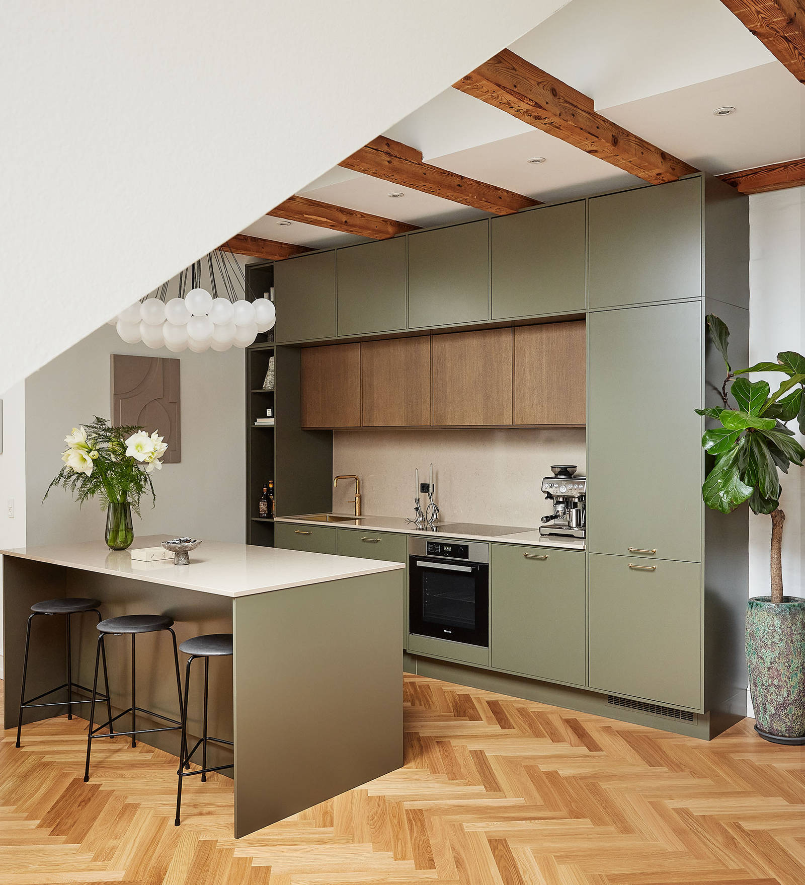 Grønt køkken med træskabe og køkkenø