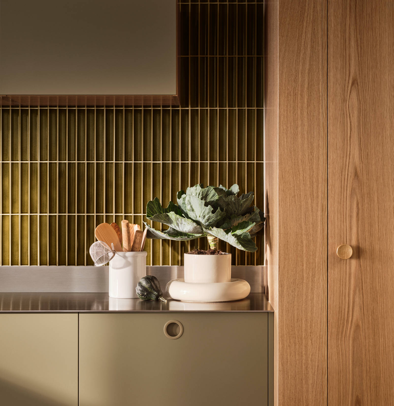 Jubilæumskøkken fra INVITA med træfinér eg, matchende vægpanel og grønne skaber inspireret av 1970'erne med infræsede greb