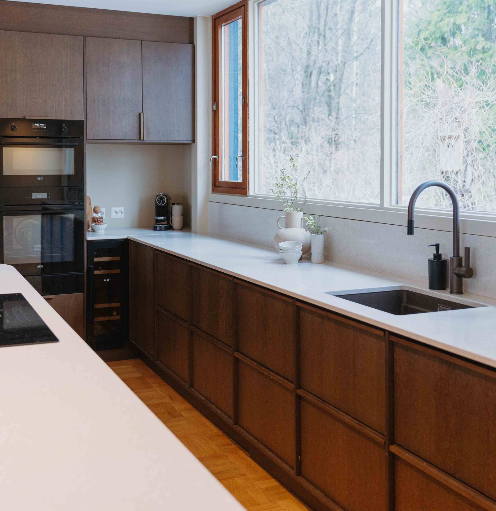 Liv och Hallvards Signatur Ekbacken-kök från Marbodal, med brunbetsad fanerad eklucka, matchande handtag i trä och bänkskiva i kvartskomposit